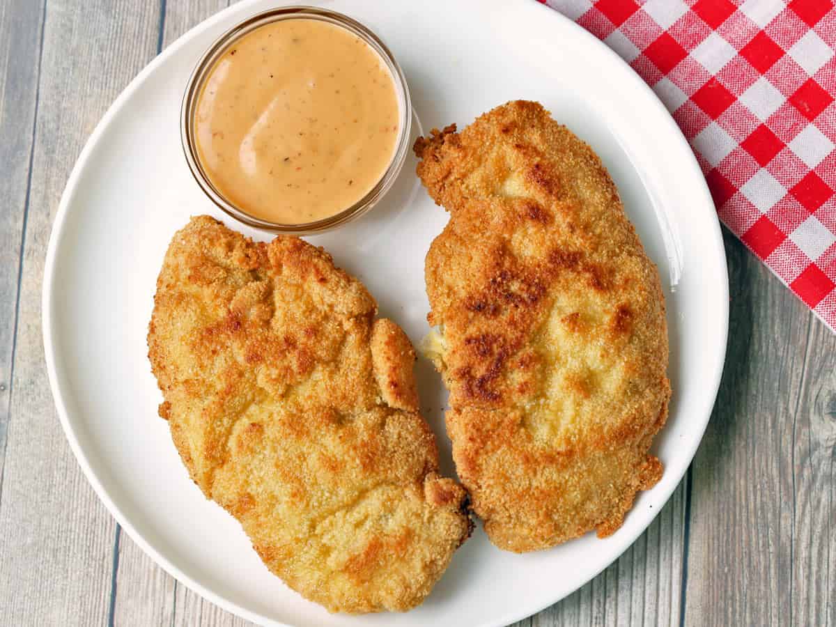 Pan-fried almond flour chicken tenders are served with a dip.