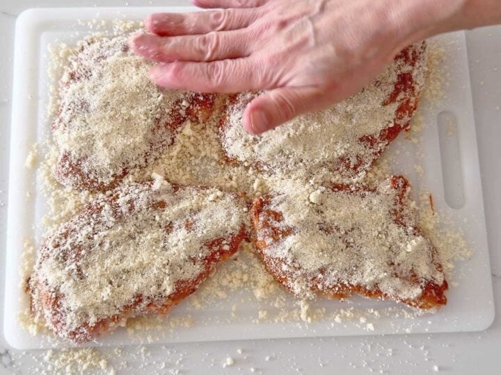 Coating the chicken with Parmesan and almond flour.
