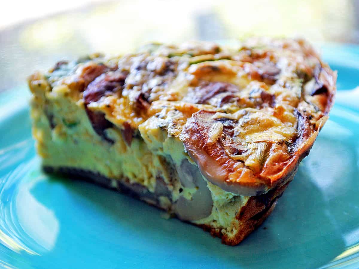 A mushroom frittata slice s served on a turquoise plate.